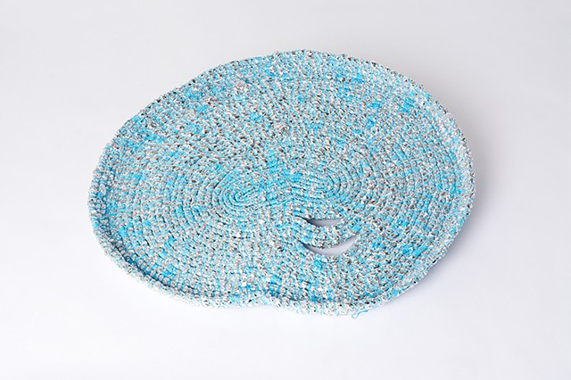 Detail of abstract coiled basket made with emergency blankets and baby blue plastic lacing by José Santiago Pérez