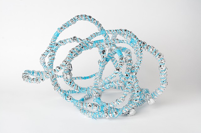 abstract basket made of baby blue plastic lacing and emergency blankets by Jose Santiago Perez