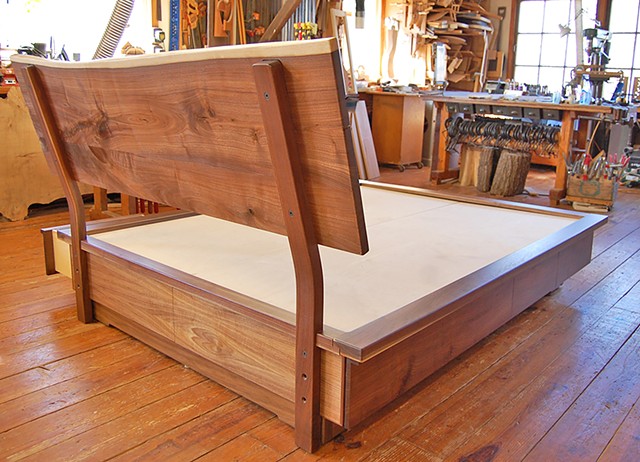 Goldyne queen-size platform storage bed.  Walnut live edge headboard with matching drawer fronts and book-matched crotch-grain footboard.  Eight drawers total.  