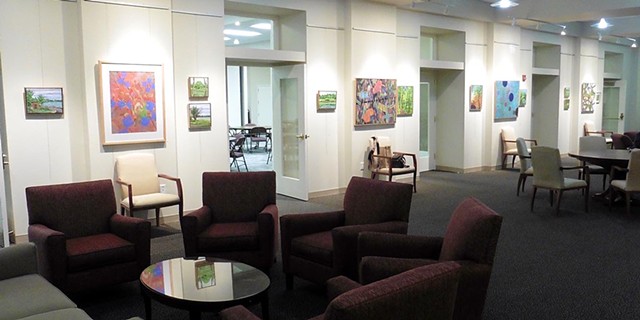 Installation photo of North gallery wall with canvas landscape and abstract paintings