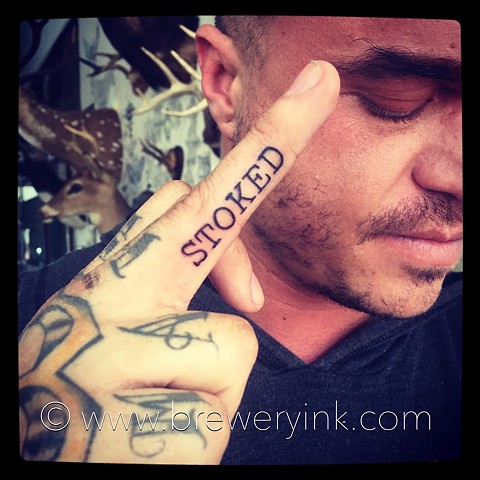 stoked finger tattoo
