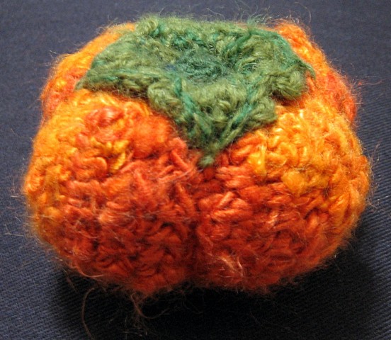 Crochet persimmon fruit toy yarn fiber art by Pat Ahern.