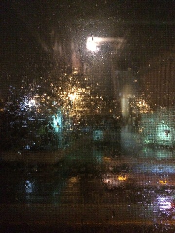 Through studio window, rainy night