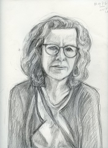 A woman wearing glasses looks intently at the viewer