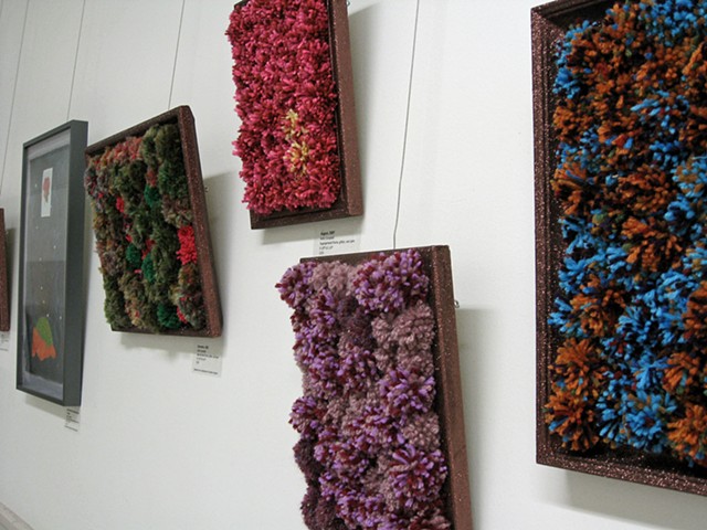 sculpture installation of brown glittered picture frames and multicolored yarn pom poms old redmond school house by Holly Campbell