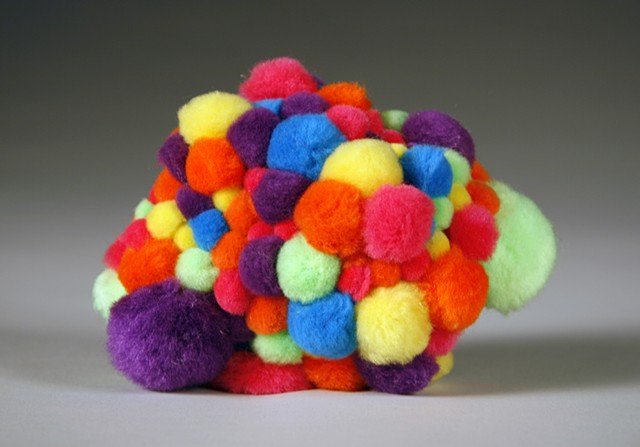 rainbow multicolored pom poms on found rock by Holly Campbell