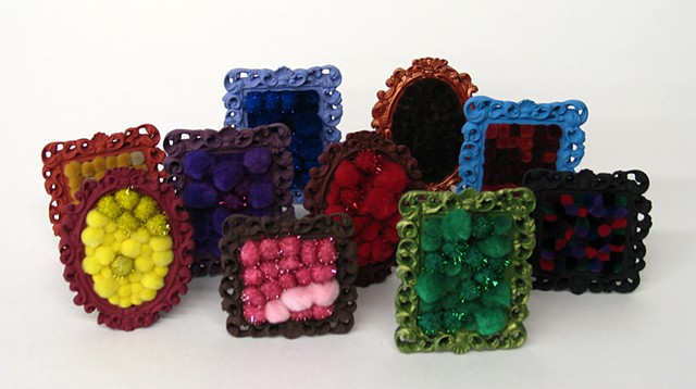found picture frame sculptures painted filled with rainbow colored yarn pom poms by Holly Campbell