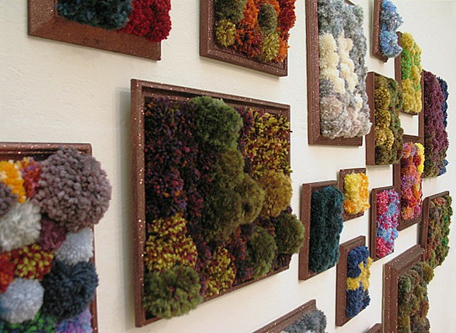 sculpture installation of brown glittered picture frames and multicolored yarn pom poms by Holly Campbell