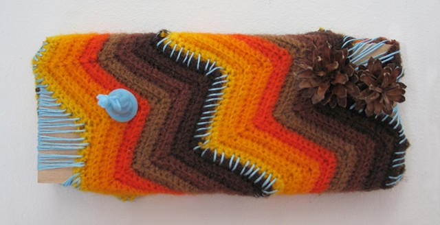 miniature toy woman standing on a yarn covered wooden landscape with pine cones sewn together by embroidery thread by Holly Campbell