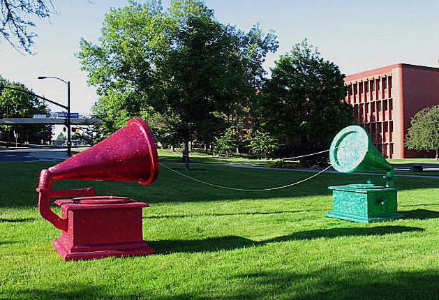 pink and green glittered phonographs with gold beaded string sitting in the grass by Holly Campbell