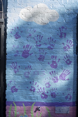 detail of purple hands in dappled sunlight