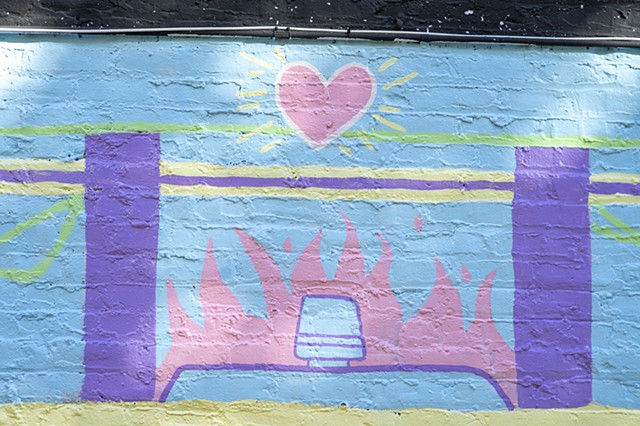 detail of burning cop car and radiating heart in dappled sunlight