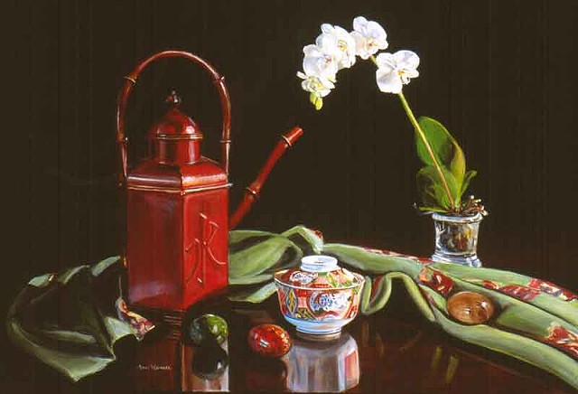 An angular red watering can with "water" in raised Chinese characters, an Imari cup, a softly folded green cloth, an Imari cup, colored eggs and a white orchid sit on a dark surface with reflections.  Colors are red, white and green. The black background 