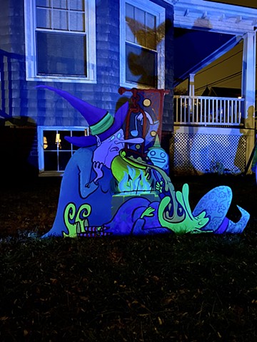 2021 Fall Witches Display lit at night. Displayed at the blue house on the corner of Kidder St. and Powder House Terrace, October - November