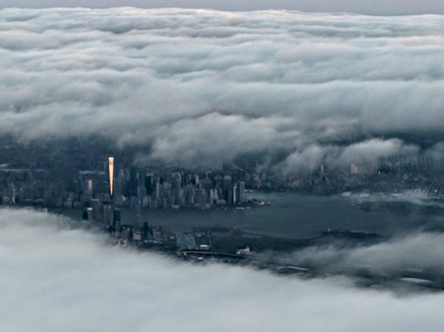 Sun glinting off Freedom Tower as seen from above clouds