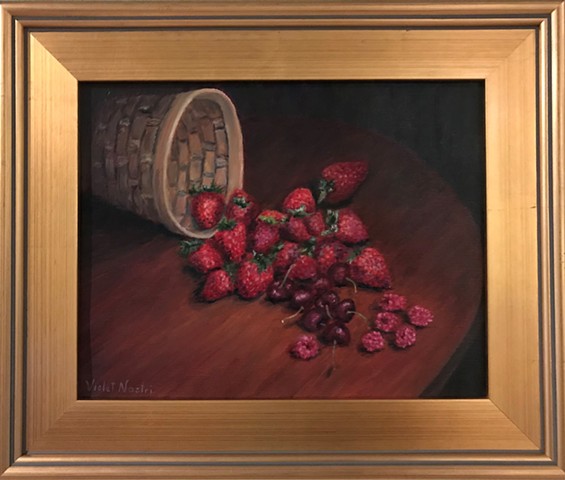 woven basket with chreeies, strawberries and raspberries spilled on table