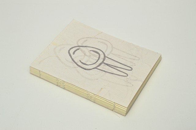 a small, white handmade book with a screen printed cover