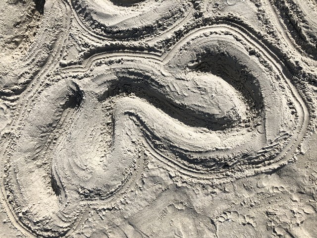 abstract, curved designs dug into the sand