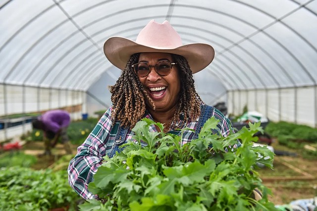 Cindy Ayers Elliott, owner and chief farmer at Foot Print Farms, the largest urban farm in the state of Mississippi, holds fresh lettuce from inside her tunnel gardens. Ayers Elliott went from working on Wall Street back to Mississippi to find her roots.