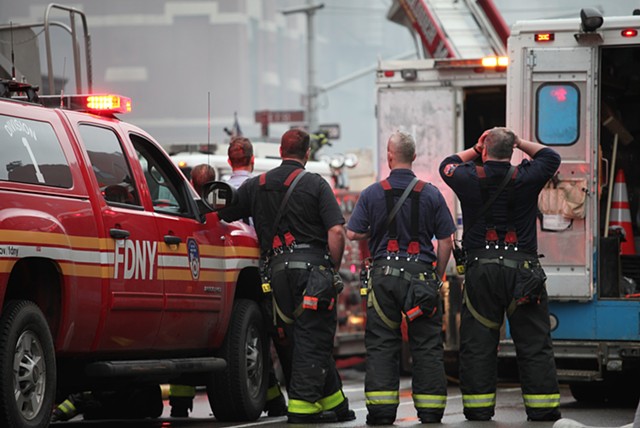 Fire fighters observe the scene of the Con Edison gas explosion and resulting fire in New York's East Village on March 26, 2015; the incident resulted in two deaths, nineteen injuries, and the complete eradication of three adjoining buildings.