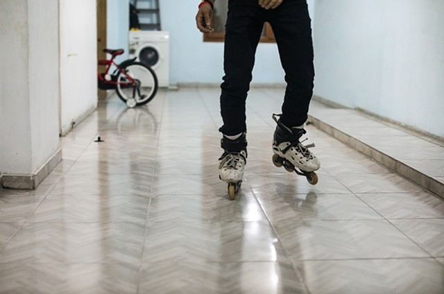Hala's eldest brother, Mahmoud, rollerblades in the family home before dinner.