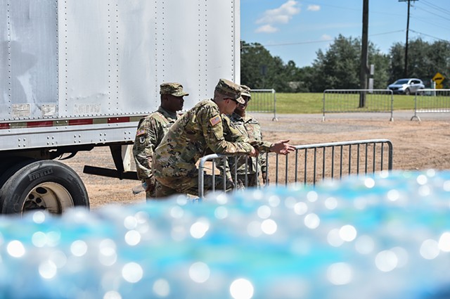 Mississippi Army National Guard SSG Preston Haynes helps direct soldiers amid pallets of water near Davis Road Park at a water distribution site in Byram, Miss., Thursday, September 1, 2022.