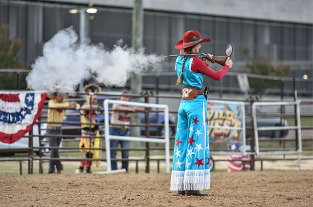 Sophie Duke, 15, playing Annie Oakley in the Great American Wild West show, performs her signature over-the-shoulder mirror shot at the Mississippi state fair, held at the state fairgrounds in Jackson, Miss. on Friday, October 7, 2022.
