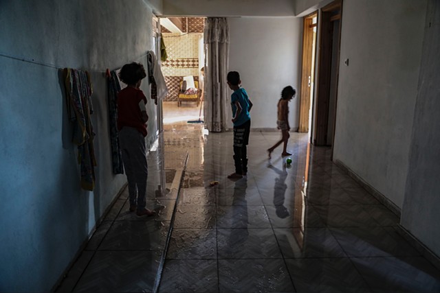 Sabiha and Bashir watch Hala play in the family’s living room after the floors are freshly washed.