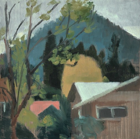 a plein air painting of rooftops, fall trees, a distant butte and a gray-white sky painted on hard board