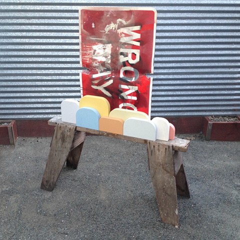 Wood sculpture made from sawhorse and wrong way traffic sign