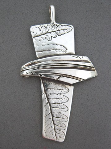 silver cross made by Nancy Denmark with impressions from nature