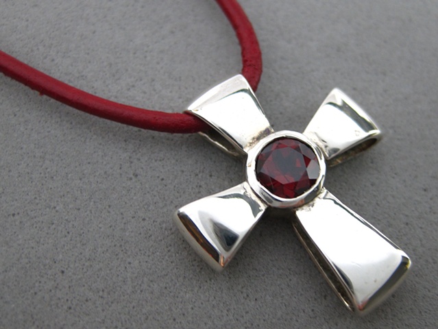 Sterling silver ribbon cross with faceted garnet ©Nancy Denmark