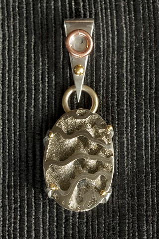 Iron pyrite ammonite set in silver accented with gold, brass, and copper by Ryan C Sedgely.