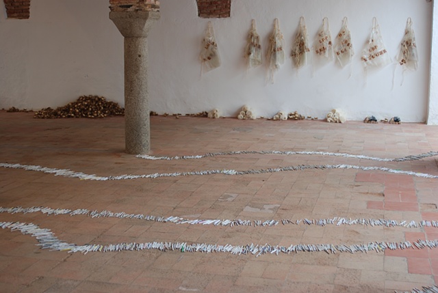 Exhibition Flying Carpet Prayers at El Psito, performance workshop props, cardus plant, and on the floor, rolled newspaper from Catalunya in the shape of Caadas Real