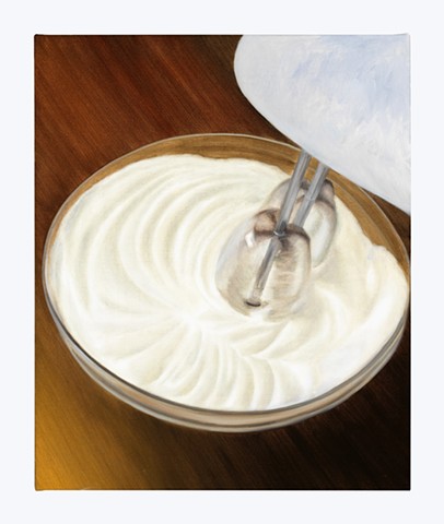 egg whites whipped in a glass bowl by a hand mixer