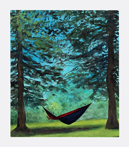 A foot sticking out of a hammock in the woods