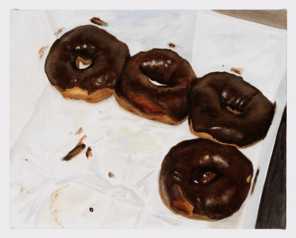 Four chocolate frosted donuts in a grease stained box