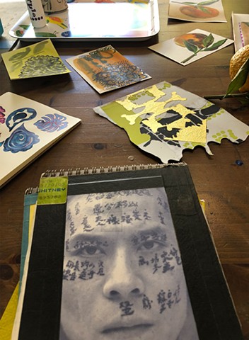 sketchbooks in foreground + small paintings, on the studio table