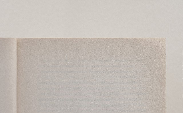 close-up of an edge of a book with a crease on a plain background