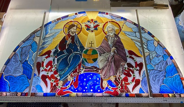 the Holy Trinity window, now painted and bonded, sits on the light table, awaiting to be glazed. 