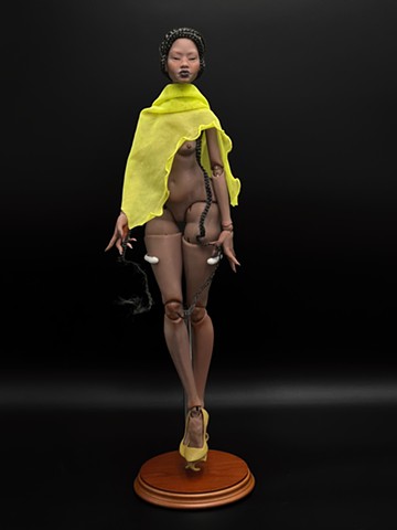 Eve No.2 is an articulated, ball-jointed doll sculpture whose nude form and serpentine hair reflect the artist’s vision of the first woman reimagined through a speculative lens. Borne out of digital sculpting and 3D printing, she emerges in a reimagined Garden of Eden as both muse and machine. She is an echo of creation rewritten through technology. Depicted as a Black woman, Eve replays the origin story in a distant, alternate timeline, merging the boundaries between myth and future.  In the tradition of doll-makers, “Eve” holds sacred meaning as the tender name given to one’s first transformative work and most beloved sculpt. She is the foundation of the artist’s practice, as both a beginning and a continual point of return, shaping every work that follows through the lessons learned in 