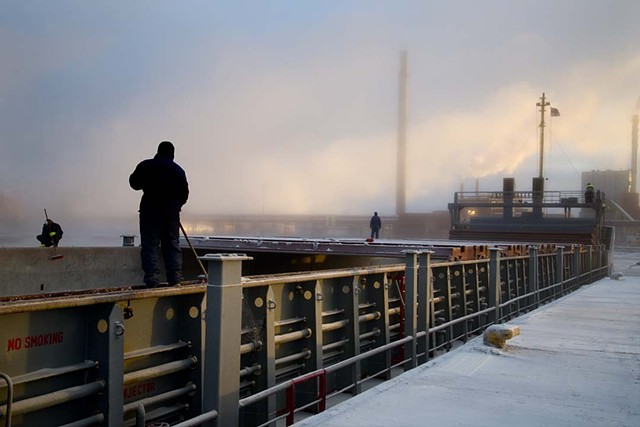 Thule deck crew scrapes the ice off of the hold lid tracks at Kotka, Finland; From "Majestic Monotony"