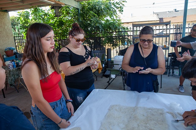 Tia/Aunt and cousins making clay impressions of silicone mold of stucco wall. Photographed by Rafael Cardenas 