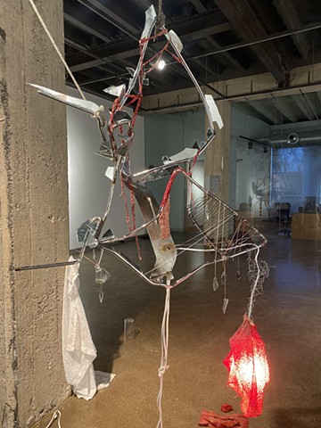 scrap metal, glass shards, fabric, annulled wire, string, light