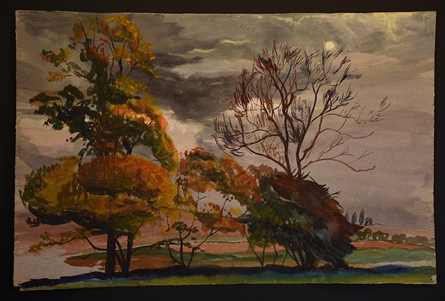 Landscape with colourful trees in the foreground, against a cloudy sky