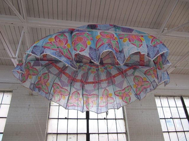 "Reentry," a sculpture consisting of a vintage military-issue silk parachute transformed into a fluttering leaded glass rose window. 