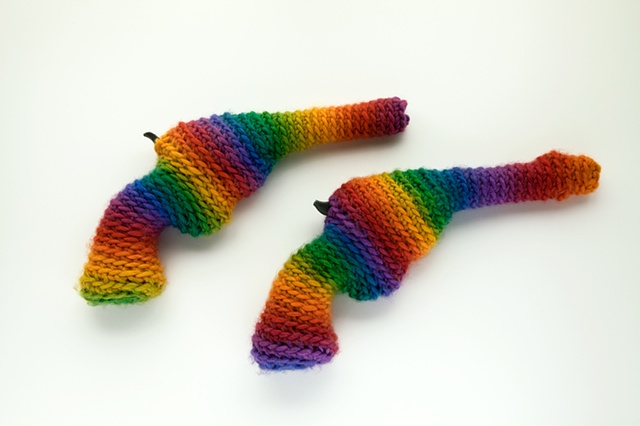 Crocheted rainbow wool yarn around replica revolvers. Crochet revolver. Modesto Covarrubias.