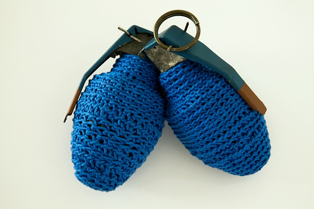 Crocheted blue cotton yarn around inert hand grenades. Crochet grenade. Modesto Covarrubias