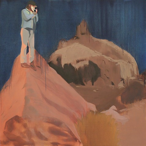 a man stands on a rock mound. behind him is an eery rock formation and dark night sky