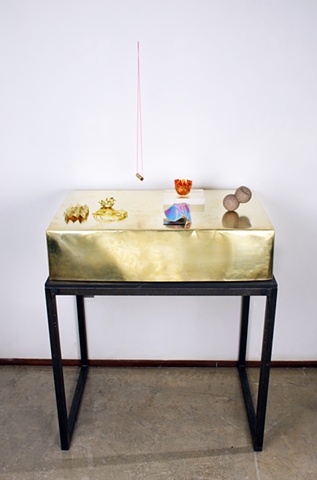 This still-life is assembled out of hand-made objects, displayed on a heated brass box. The box acts as a body, and the objects are like jewelry.

